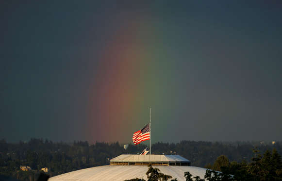 A rainbow appears behind the U.S. flag flying at half-staff on top of the Tacoma Dome, Monday, June 13, 2016, in Tacoma, Wash. Flags across the state were at half-staff Monday to honor the victims of a mass shooting early Sunday at a gay nightclub in Orlando, Florida.