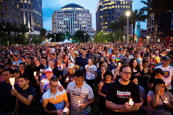 Crowd members hold candles during a vigil downtown for the victims of a mass shooting at the Pulse nightclub Monday, June 13, 2016, in Orlando, Fla.