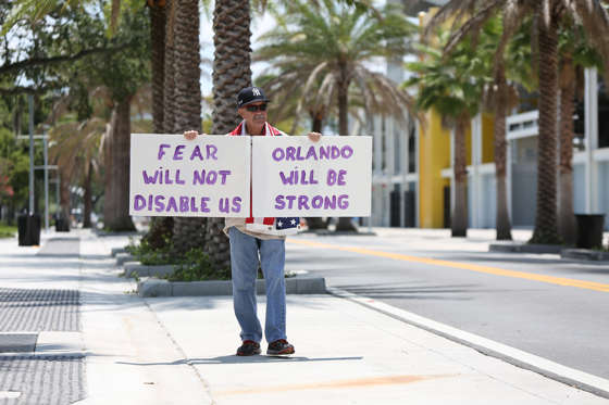 Andy Garcia, a longtime resident of Orlando, holds signs outside Camping World Stadium in Orlando, Fla., on Wednesday, June 15, 2016, to show support to those affected by the Pulse nightclub shooting. (Joshua Lim/Orlando Sentinel/TNS via Getty Images)