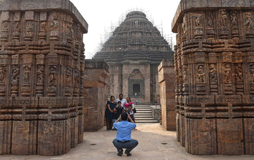 Tourists visits the Konark Sun temple in Konark, in eastern Orissa state on December 12, 2014. The Konark Sun Temple is a 13th-century Sun Temple built by King Narasimhadeva I of the Eastern Ganga Dynasty around 1250. The temple, a UNESCO World Heritage Site, has been built in the shape of a gigantic chariot with elaborately carved stone wheels, pillars and walls and a major part of the structure is now in ruins.