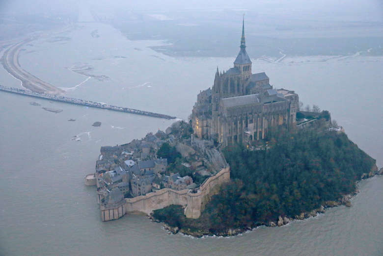 An aerial view shows the Mont Saint-Michel off France's Normandy coast March 20, 2015. The Mont Saint-Michel 11th century abbey is expected to be entirely surrounded by the English Channel following exceptionally high spring tides. Parts of the French coast will be on alert for the so-called "tide of the century", with tidal coefficients of 118 and 119 respectively on March 20 and 21.