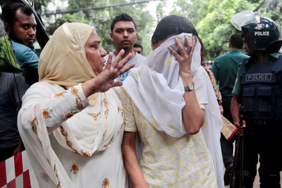 A relative tries to console Semin Rahman, covering face, whose son is missing after militants took hostages in a restaurant popular with foreigners in Dhaka, Bangladesh, Saturday, July 2, 2016. Bangladeshi forces stormed the Holey Artisan Bakery in Dhaka's Gulshan area where heavily armed militants held dozens of people hostage Saturday morning, rescuing some captives including foreigners at the end of the 10-hour standoff. [AP Photo)