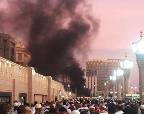 In this photo provided by Noor Punasiya, people stand by an explosion site in Medina, Saudi Arabia, Monday, July 4, 2016. State-linked Saudi news websites reported an explosion Monday near one of Islam's holiest sites in the city of Medina, as two suicid