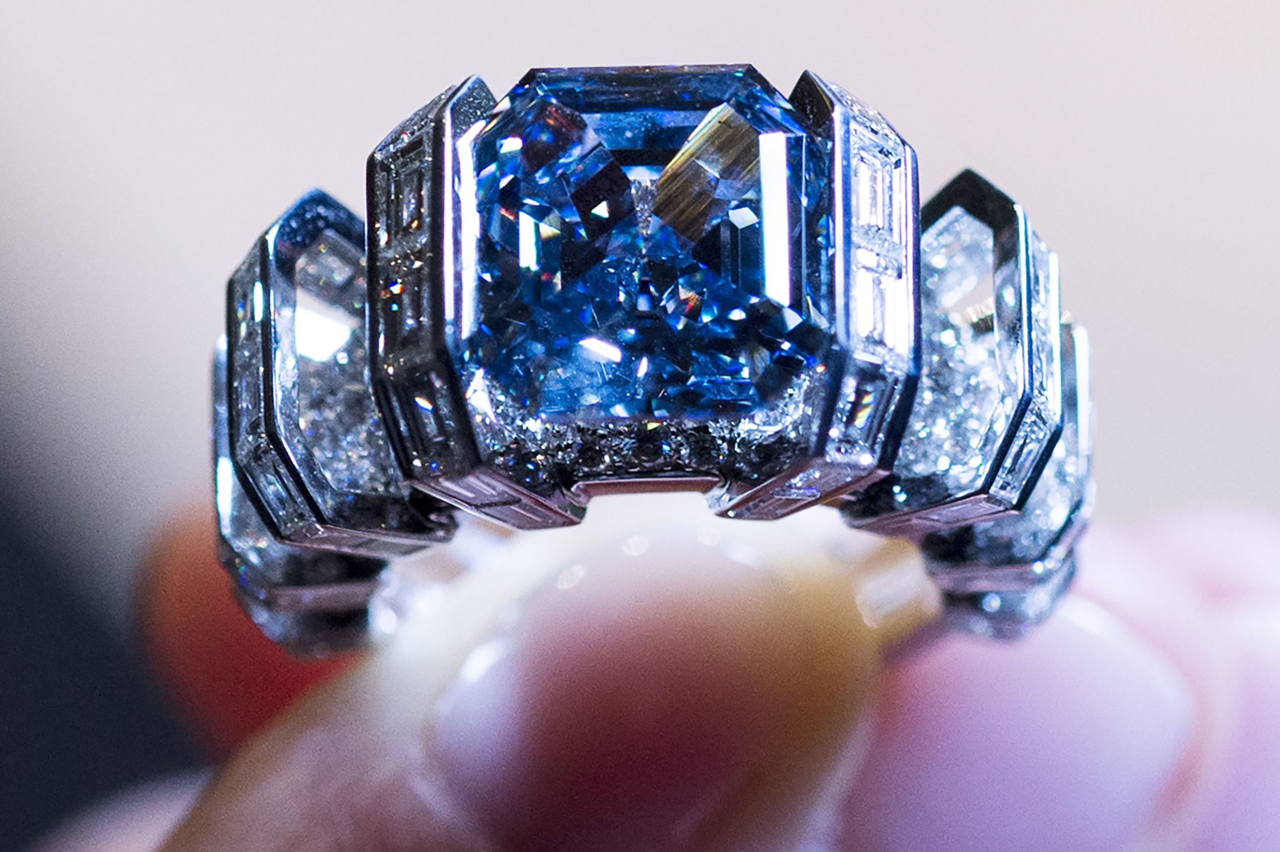 LONDON, UNITED KINGDOM - OCTOBER 11: Model Jasmine Taylor Salah holds a blue diamond weighing 8.01 carats mounted a ring by Cartier with an estimate of $15-25 million as part of Sotheby's November auction of Magnificent Jewels & Noble Jewels in Geneva on