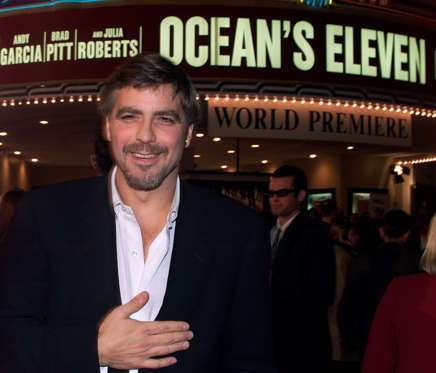 Actor George Clooney, one of the cast members of the new film "Ocean's Eleven" poses with the theater marquee in background at the film's premiere December 5, 2001 in Los Angeles. The film also stars Brad Pitt and Julia Roberts and opens December 7 in the United States.