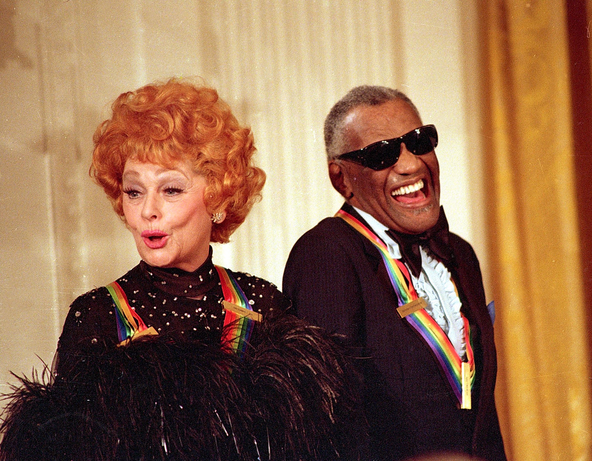 Entertainer Lucille Ball and singer Ray Charles, recipients of the Kennedy Center Honors, react during comments made by U.S. President Ronald Reagan during a tribute to the performers at the White House on Sunday, Dec. 7, 1986.