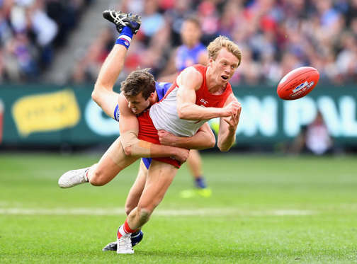 MELBOURNE, AUSTRALIA - OCTOBER 01:  Callum Mills of the Swans handballs whilst being tackled by Zaine Cordy of the Bulldogs during the 2016 AFL Grand Final match between the Sydney Swans and the Western Bulldogs at Melbourne Cricket Ground on October 1, 