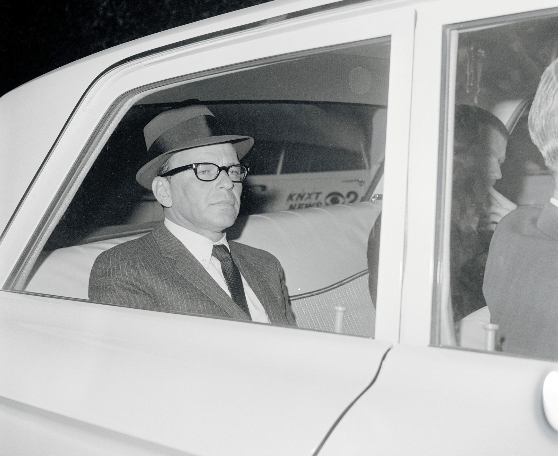 Frank Sinatra returns to the home of ex-wife, Nancy, after paying $240,000 for the safe return of his kidnapped son, Frank Jr. Sinatra is shown in back seat of FBI car. He said he had talked with Frank Jr. twice during eight telephone conversations with kidnappers in two days. The first call was to his Reno motel.