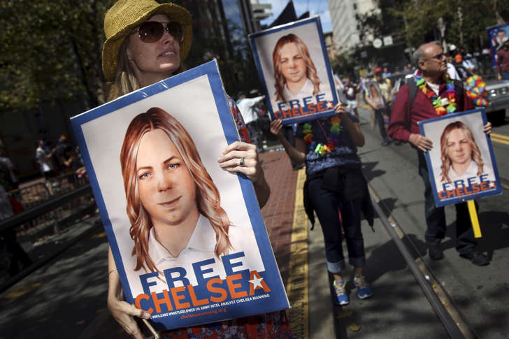 People hold signs calling for the release of imprisoned wikileaks whistleblower Chelsea Manning while marching in a gay pride parade in San Francisco, California June 28, 2015.
