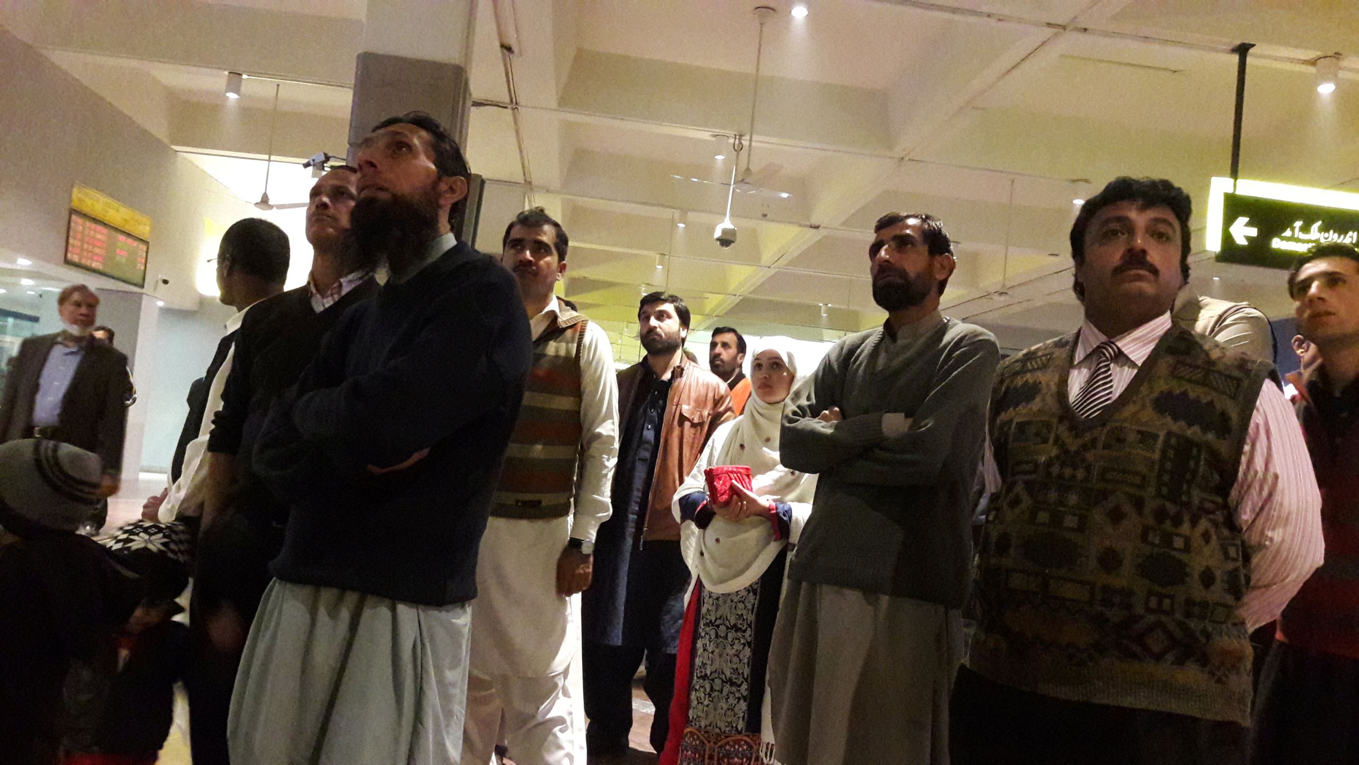 People watch television coverage of the PIA plane crash, at the Benazir Bhutto International Airport in Rawalpindi, Pakistan December 7, 2016.