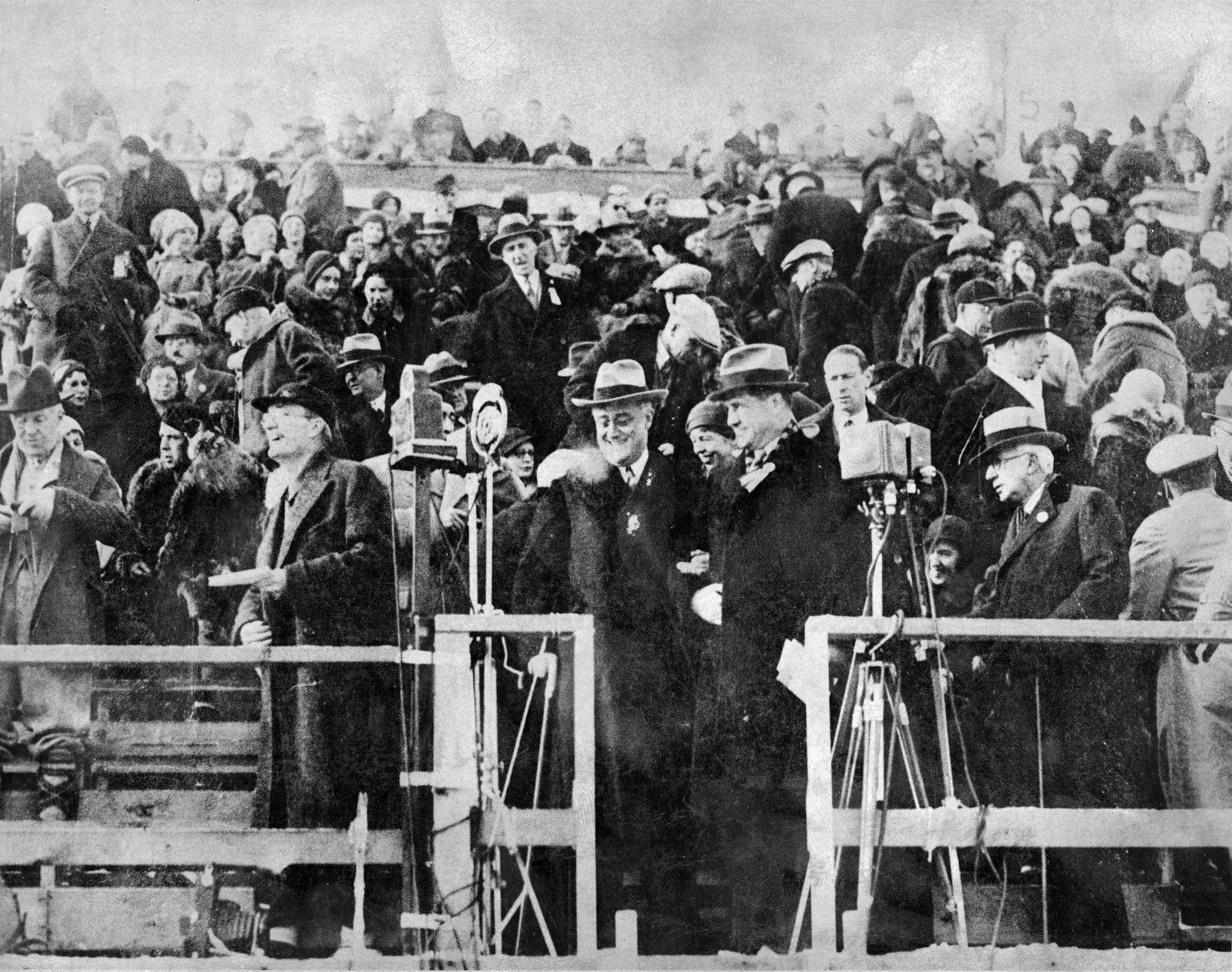 Slide 3 of 15: International Olympic Committee President Count Henri de Baillet-Latour (1876 - 1942) (center right, with hand inside his coat) stands with American politician and New York Governor (and later US President) Franklin D. Roosevelt (1882 - 1945) (center) during the opening ceremonies of Winter Olympics, Lake Placid, New York, February 4, 1932.