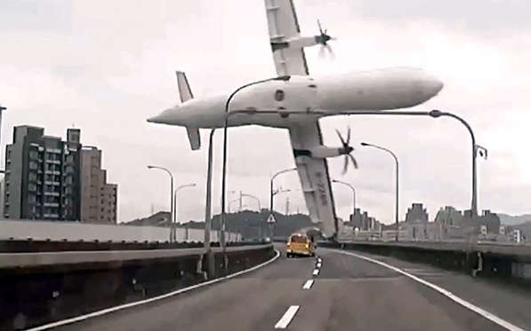 Slide 15 of 15: TVBS screen grab taken from a video shows a TransAsia ATR 72-600 turboprop plane clipping an elevated motorway and hitting a taxi before crashing into the Keelung river outside Taiwan's capital Taipei in New Taipei City, killing at least 31 people.