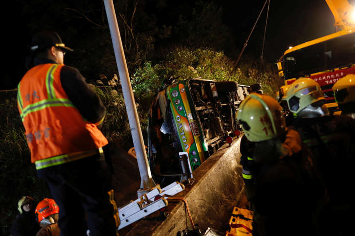 Rescuers gather around a crashed bus in Taipei, Taiwan February 13, 2017.
