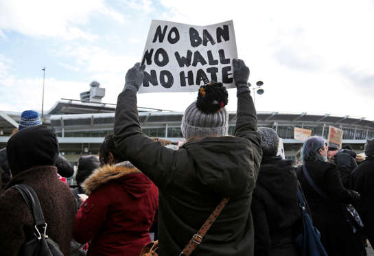 Slide 1 of 32: Protesters rally in front of John F. Kennedy International Airport in New York, Sunday, Jan. 29, 2017. President Donald Trump's immigration order sowed more chaos and outrage across the country Sunday, with travelers detained at airports, panicked families searching for relatives and protesters registering opposition to the sweeping measure that was blocked by several federal courts. (AP Photo/Seth Wenig)