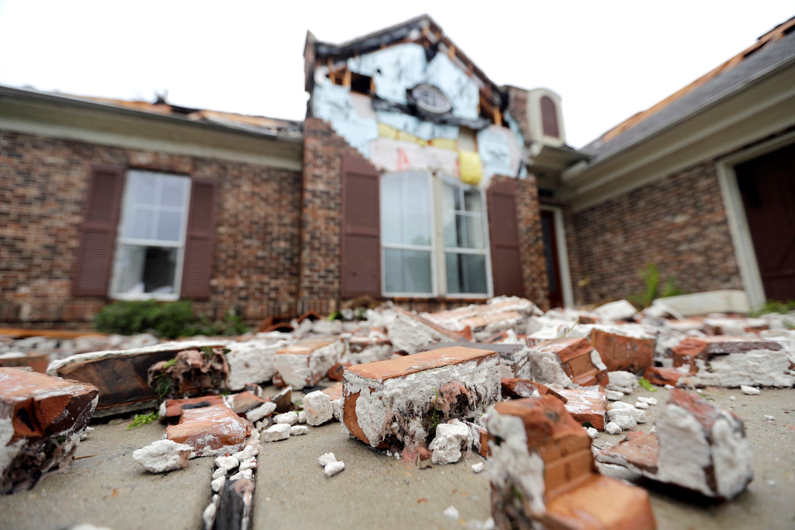 Slide 32 of 77: Fallen bricks from a home damaged by Hurricane Harvey sit on the ground Saturday, Aug. 26, 2017, in Missouri City, Texas.  Harvey rolled over the Texas Gulf Coast on Saturday, smashing homes and businesses and lashing the shore with wind and rain so intense that drivers were forced off the road because they could not see in front of them.