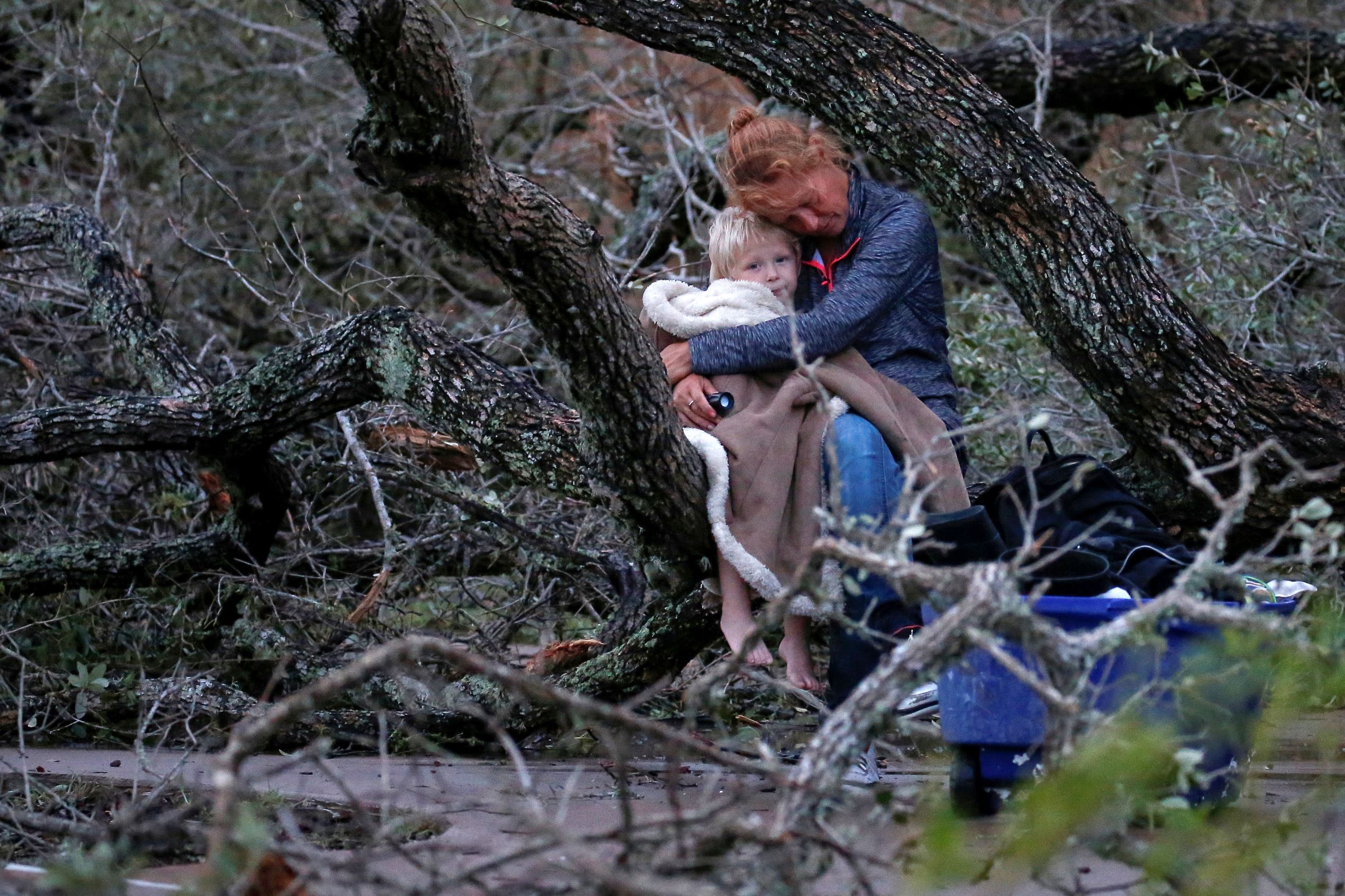 Slide 9 of 77: Lisa Rehr holds her four-year old son Maximus, after they lost their home to Hurricane Harvey, as they await to be evacuated with their belongings from Rockport, Texas, U.S. August 26, 2017.