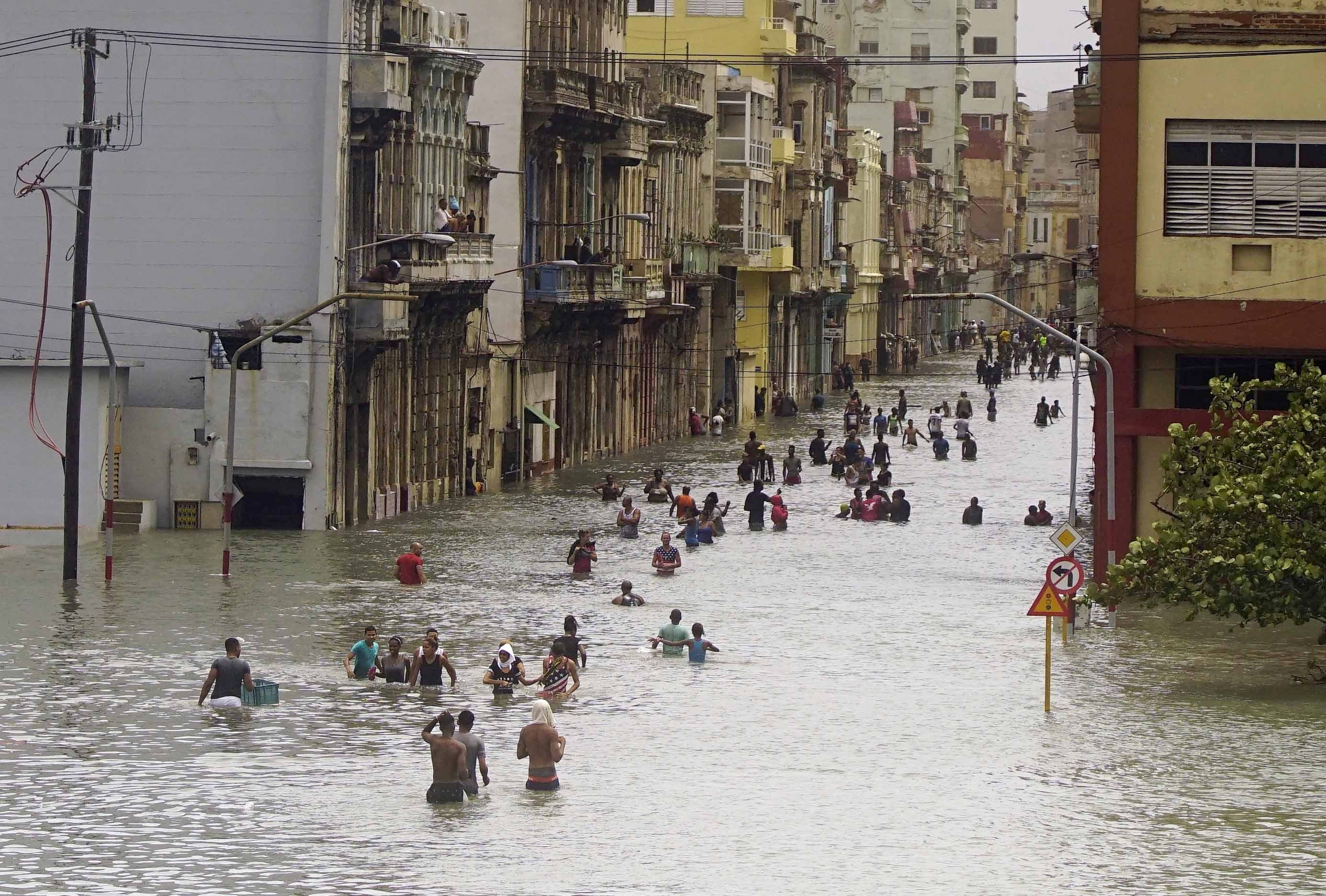 People move through flooded streets in Havana after the passage of Hurricane Irma, in Cuba, Sunday, Sept. 10, 2017.