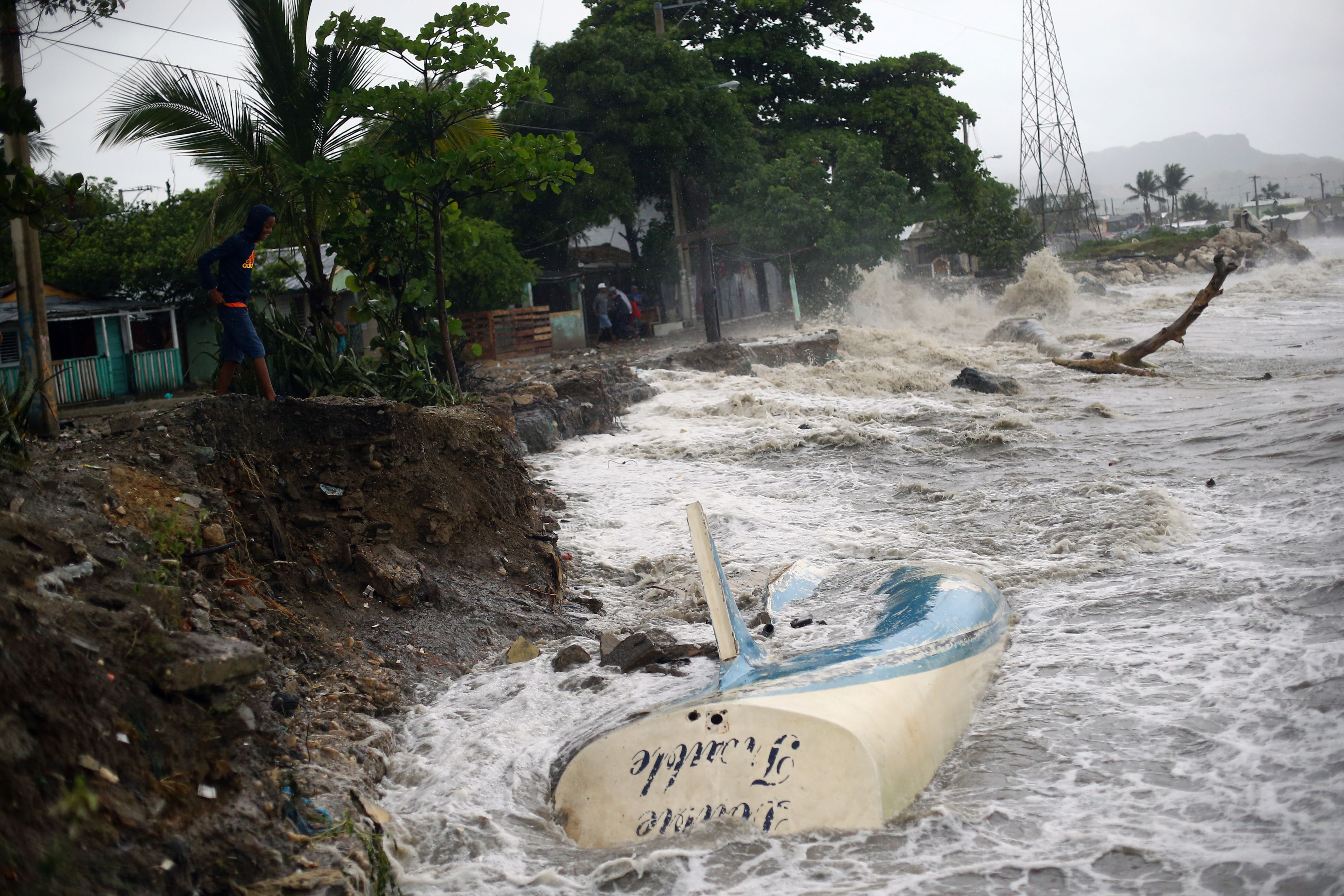 Waves crash against the shore and a stranded boat as Hurricane Irma moves off from the northern coast of the Dominican Republic, in Puerto Plata, Dominican Republic September 7, 2017. REUTERS/Ivan Alvarado - RC16EA9983F0