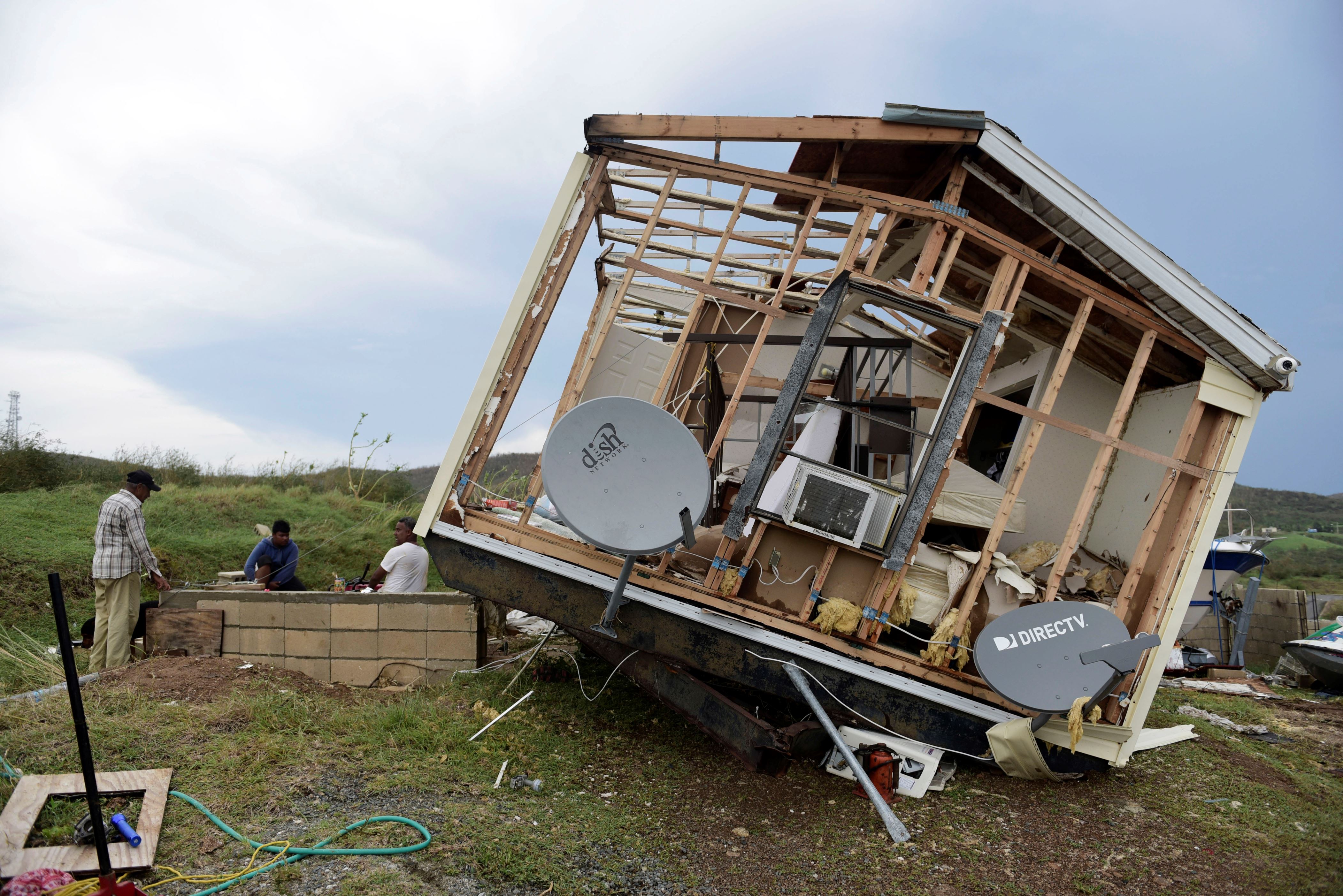 Juan Negron, right, prepares to start up a power generator in front of whats left of his damaged property, after the passage of Hurricane Irma, in the island of Culebra, Puerto Rico, Thursday, Sept. 7, 2017. About a million people were without power in the U.S. territory after Irma passed just to the north, lashing the island with heavy wind and rain. Nearly 50,000 also were without water. (AP Photo/Carlos Giusti)