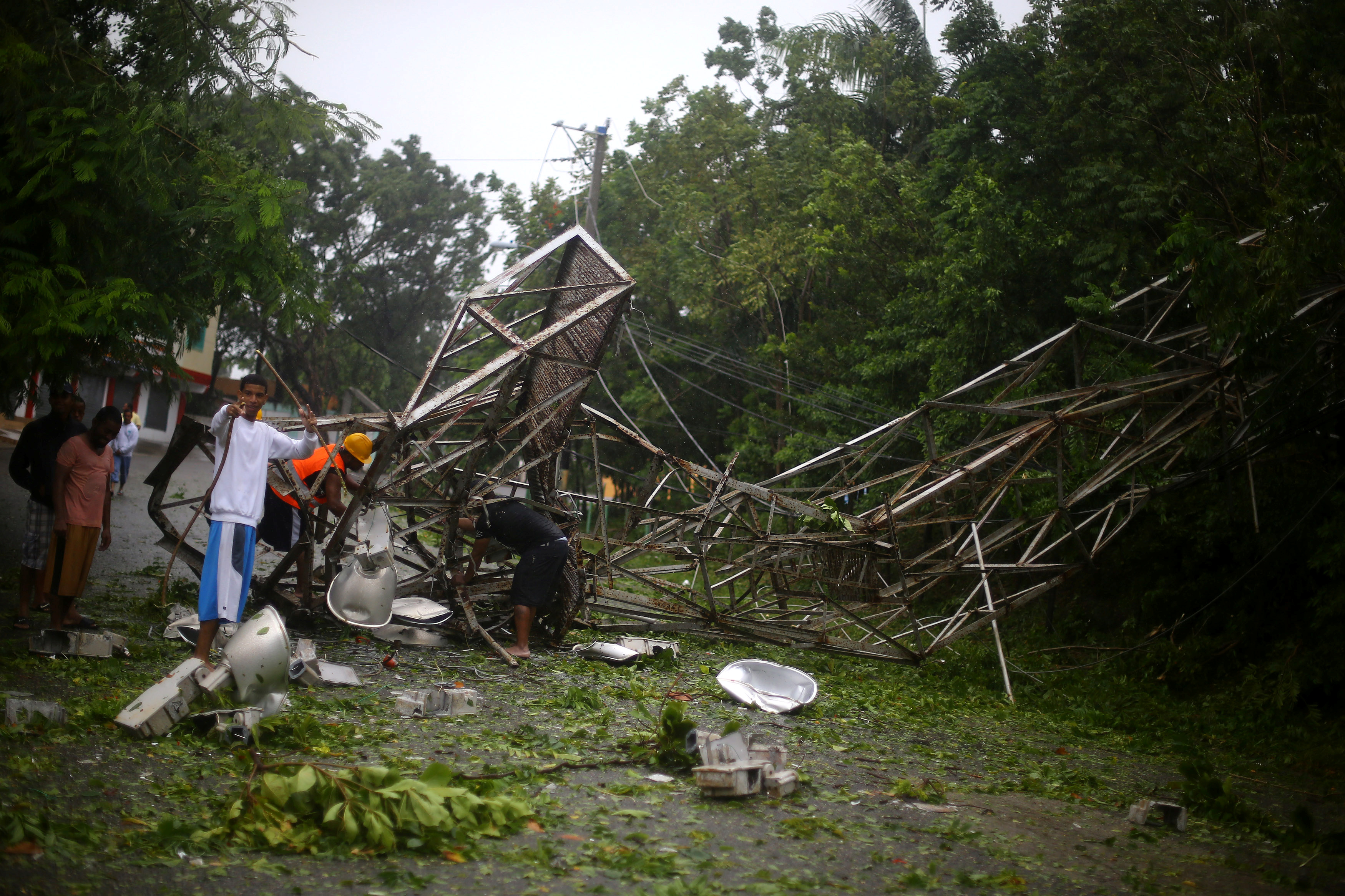 Locals remove pieces from a fallen stadium lighting tower as Hurricane Irma moves off the northern coast of the Dominican Republic, in Puerto Plata, Dominican Republic September 7, 2017.