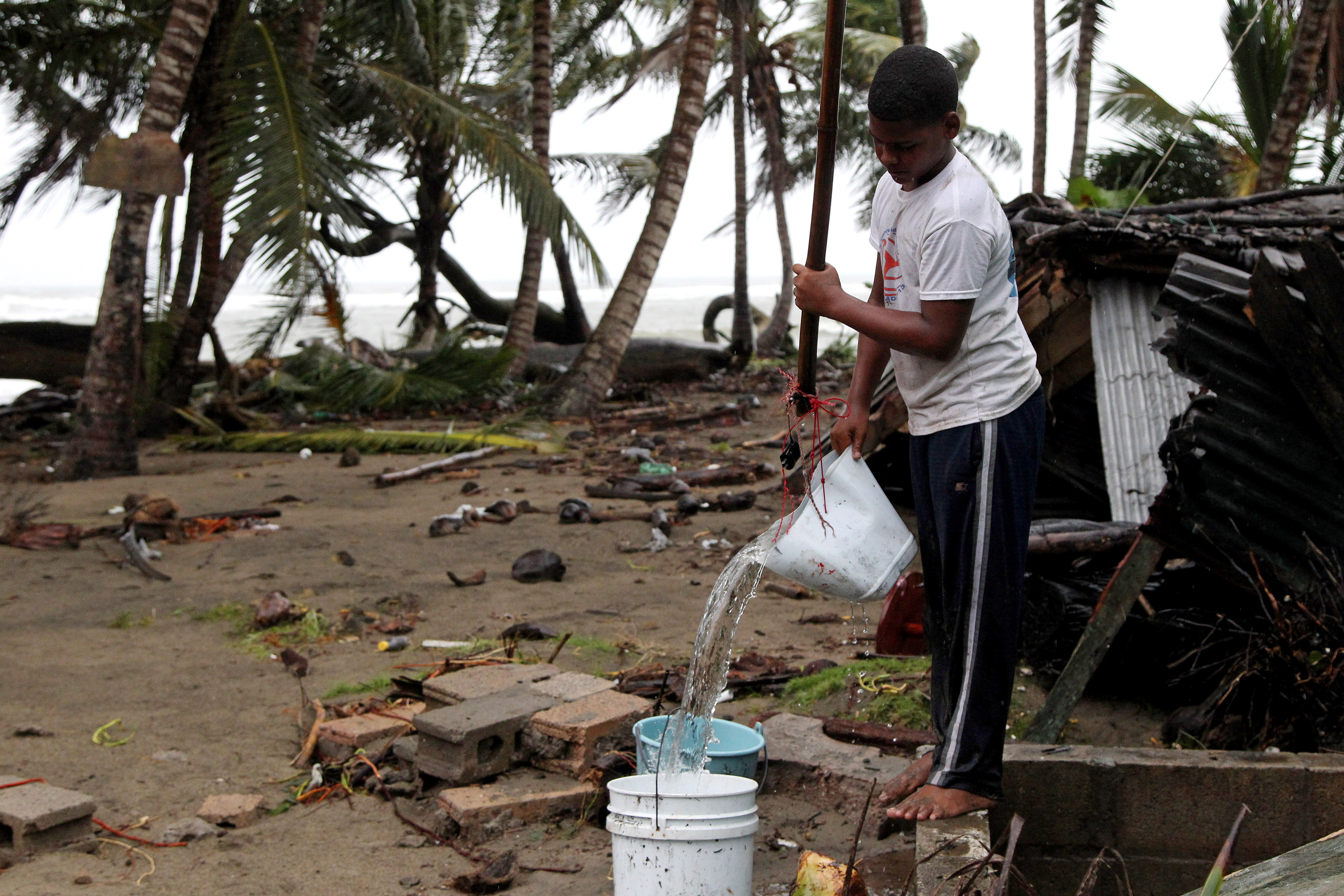 A child fills a bucket with water as Hurricane Irma moves off the northern coast of the Dominican Republic, in Nagua, Dominican Republic, September 7, 2017.