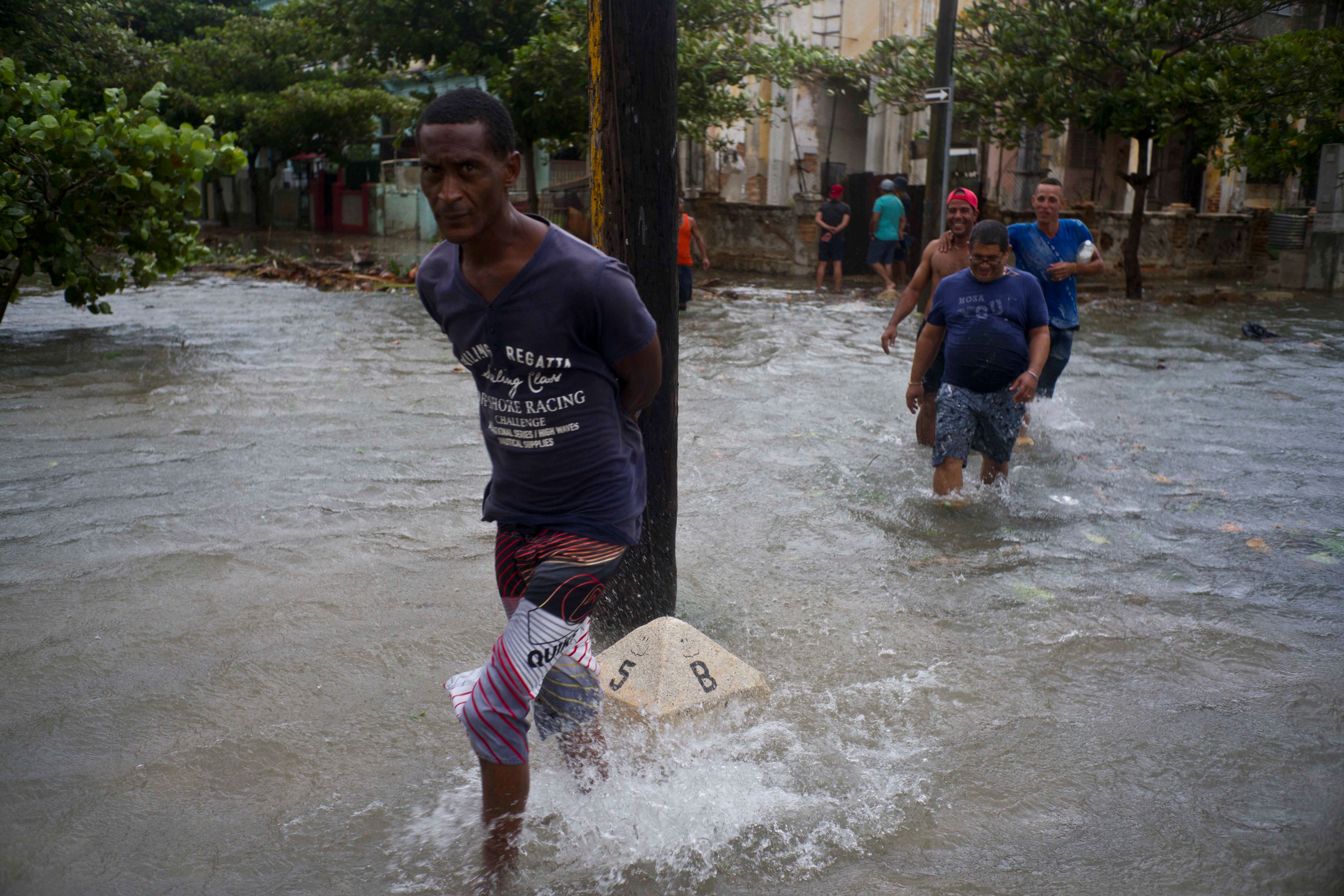 Men wade through a flooded street, caused by the passing of Hurricane Irma in Havana, Cuba, early evening Saturday, Sept. 9, 2017. (AP Photo/Ramon Espinosa)
