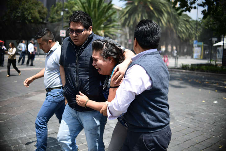 People react after a strong earthquake strikes in Mexico City on Tuesday. The city was holding preparation earthquake drills on the anniversary of a 1985 temblor.