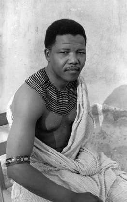 Slide 2 of 17: South African anti-apartheid revolutionary Nelson Mandela (1918 - 2013) wearing traditional beads and a bed spread  during his time in hiding from the police, South Africa, 1961. (Photo by: Eli Weinberg/Universal History Archive/UIG via Getty Images)