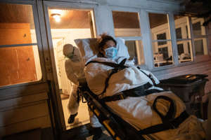 Paramedics bring home a woman with covid-19 who underwent an emergency C-section because she was gravely ill. After extensive care, including time on a ventilator, she was released from a hospital in Stamford, Conn., and she has a healthy newborn. (John Moore/Getty Images)