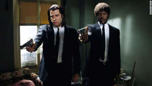 John Travolta, Samuel L. Jackson are posing for a picture: Quentin Tarantino's second film radically divided critics. Some saw the film as “a spectacularly entertaining piece of pop culture,” while others saw it as “empty,” and made by a director who “doesn’t seem to know anything at all about real life, and maybe he has no interest in it either.” Others outright accused Tarantino of living “exclusively in a boy’s fantasy world, where women and any semblance of reality are only intruders.”