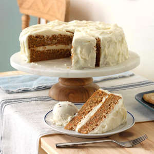a piece of cake sitting on top of a table: A pleasingly moist cake, this treat is the one I requested that my mom make each year for my birthday. It's dotted with sweet carrots and a hint of cinnamon. The fluffy buttery frosting is scrumptious with chopped walnuts stirred in. One piece of this homemade carrot cake is never enough—better than all the other carrot cakes recipes I've tried!—Kim Orr, West Grove, Pennsylvania Get Recipe