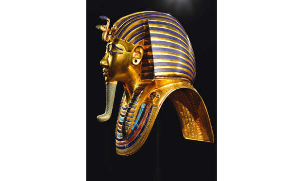Slide 3 of 29: Nicknamed the death mask, it weighs roughly 10.23kg (22.5 pounds) and shows the king wearing a royal neme (meaning striped) headdress and fake beard. On his forehead are the goddesses Nekhbet (a vulture) and Wadjet (a cobra) while the back of the mask features inscriptions from the Book of the Dead, an ancient text. The mask is one of the most iconic symbols of ancient Egypt.