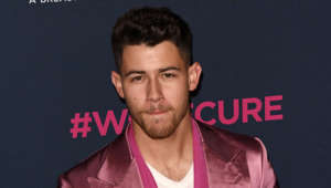 Nick Jonas wearing a pink shirt