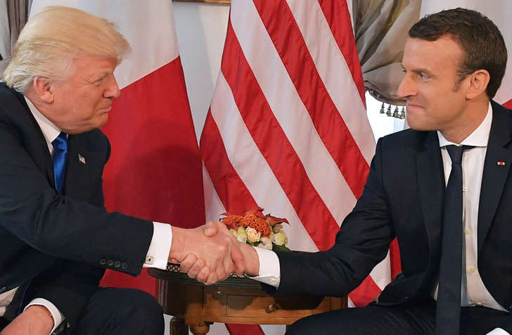 US President Donald Trump (L) and French President Emmanuel Macron (R) shake hands ahead of a working lunch, at the US ambassador's residence, on the sidelines of the NATO (North Atlantic Treaty Organization) summit, in Brussels, on May 25, 2017.