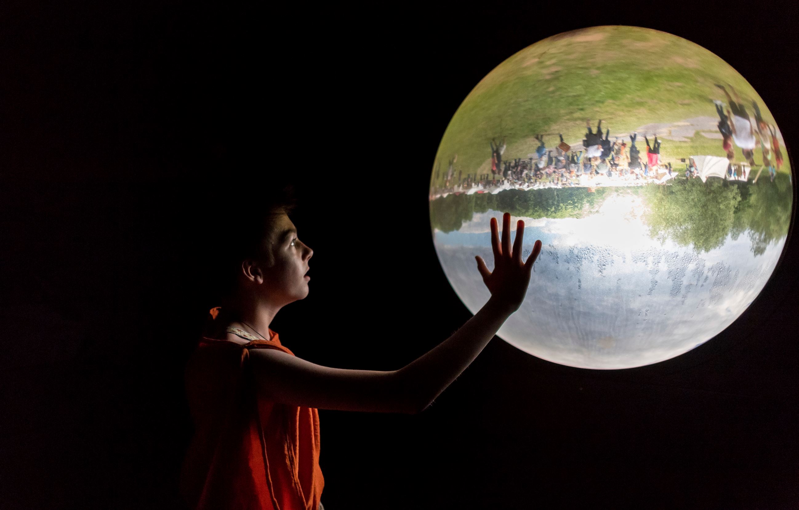 Slide 6 de 36: A boy looks at a glass bowl showing the outside upside down in a museum in Bramsche-Kalkriese, Germany, Sunday, June 4, 2017. (Guido Kirchner/dpa via AP)