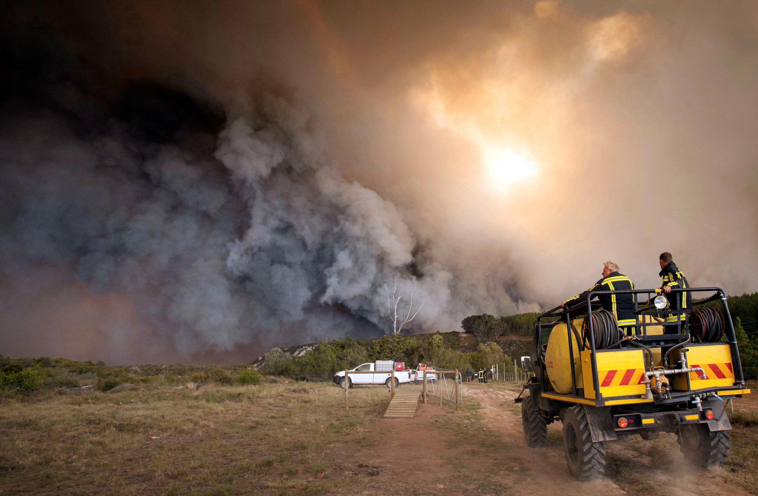 Slide 1 of 101: In this photo taken Wednesday, June 7, 2017, firemen fight a blaze in the Kranshoek area in South Africa. Fires fanned by high winds have swept through a scenic coastal town in South Africa, killing several people, destroying homes and forcing the evacuation of up to 10,000 people, authorities and media reports said Thursday. (AP Photo/Ewald Stander)