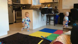 a little boy that is standing in a room: Twin babies create awesome optical illusion for camera