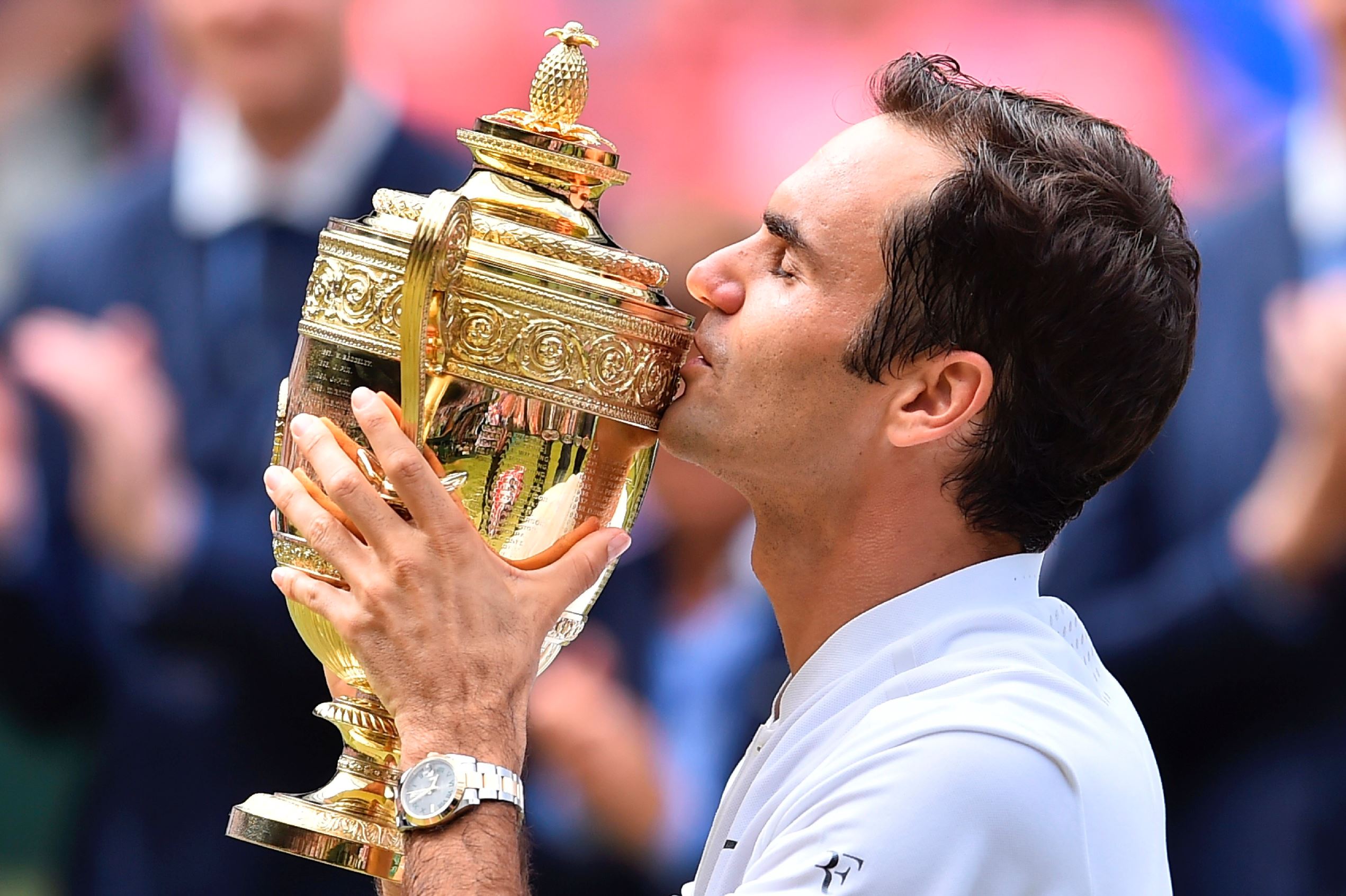 Switzerland's Roger Federer kisses the winner's trophy after beating Croatia's Marin Cilic in their men's singles final match, during the presentation on the last day of the 2017 Wimbledon Championships at The All England Lawn Tennis Club in Wimbledon, southwest London, on July 16, 2017. Roger Federer won 6-3, 6-1, 6-4.