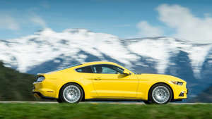 a small yellow car parked in a parking lot: 2018 Ford Mustang