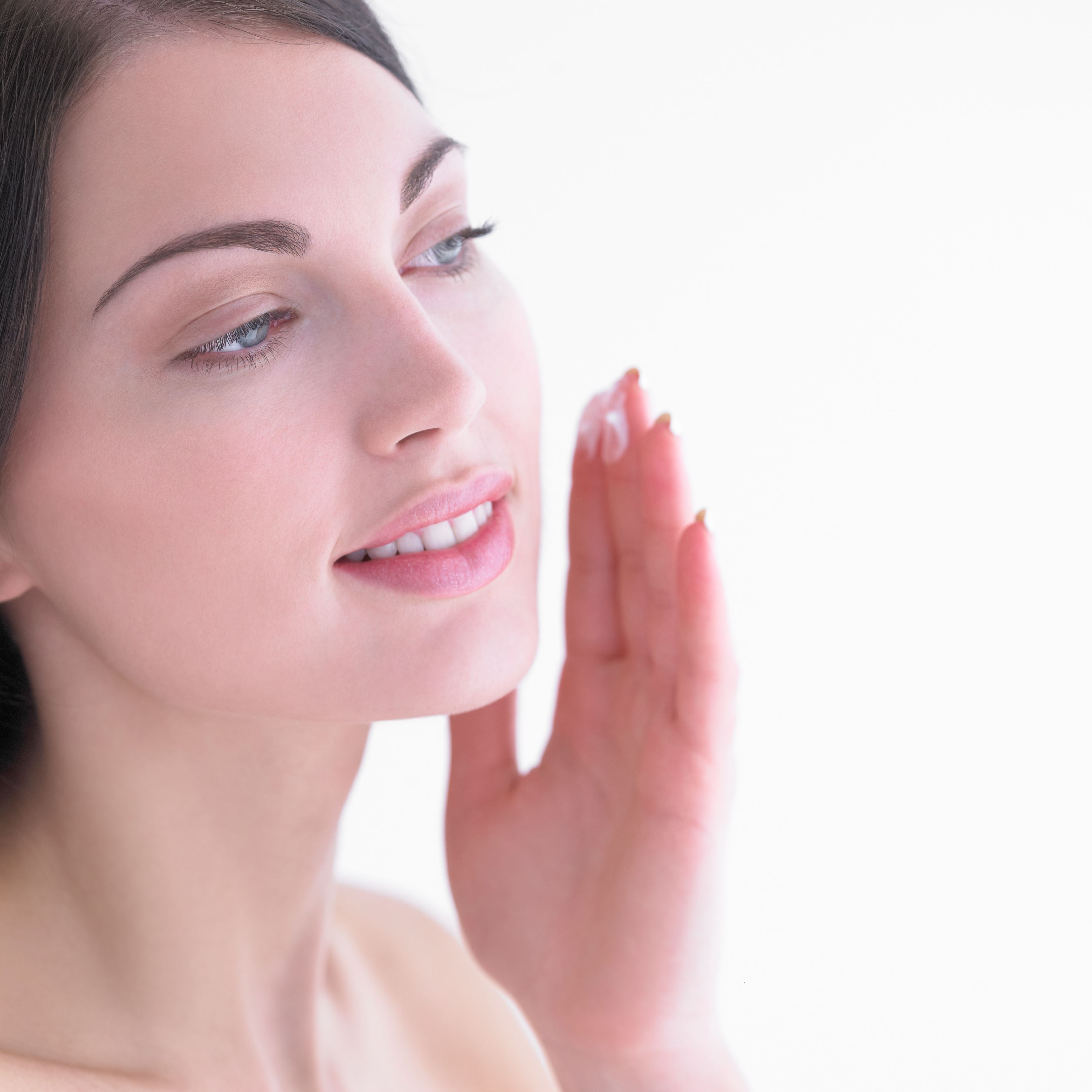 Woman applying moisturiser