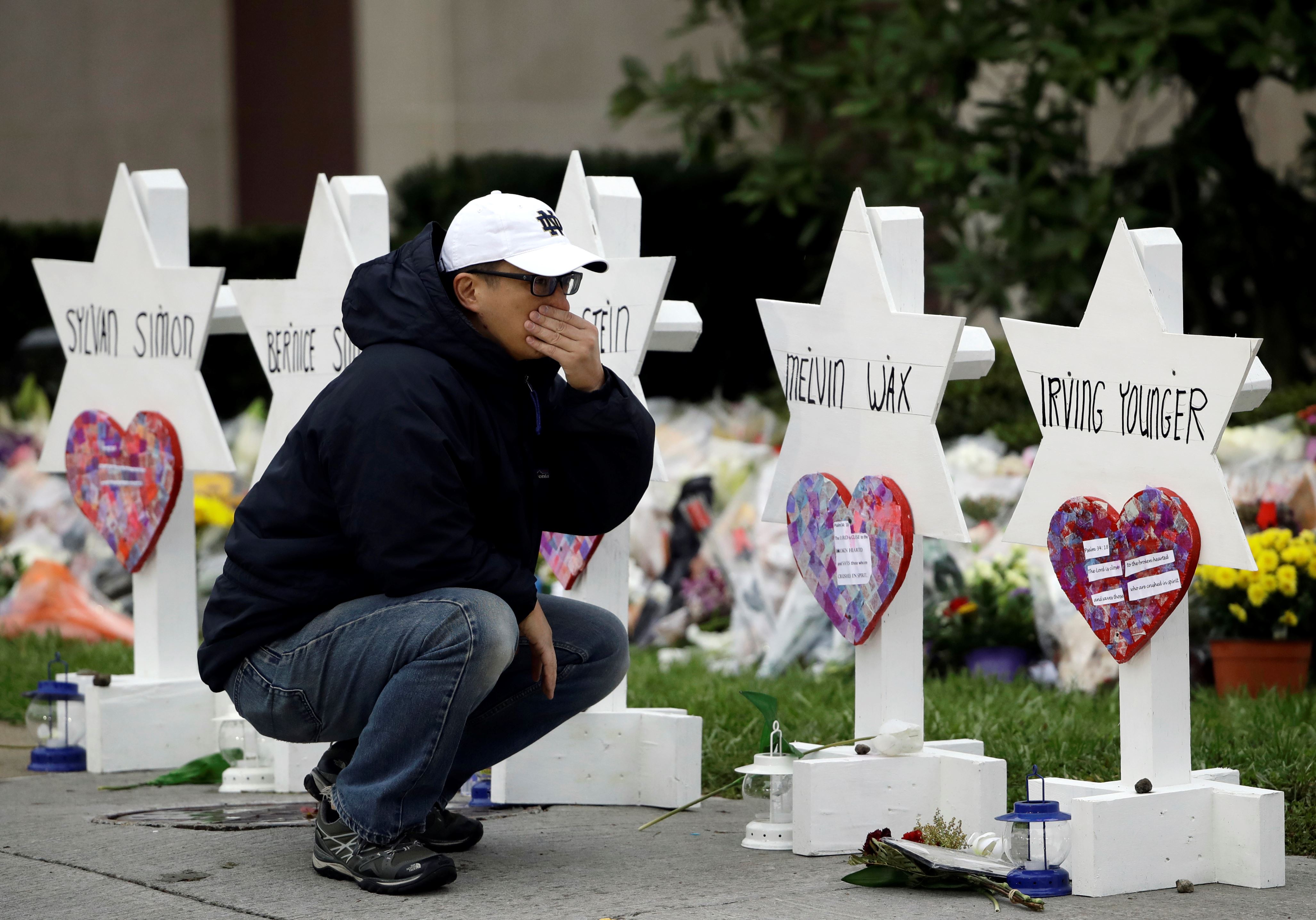 A person pauses in front of Stars of David with the names of those killed in a deadly shooting at the Tree of Life Synagogue, in Pittsburgh, Monday, Oct. 29, 2018. (AP Photo/Matt Rourke)