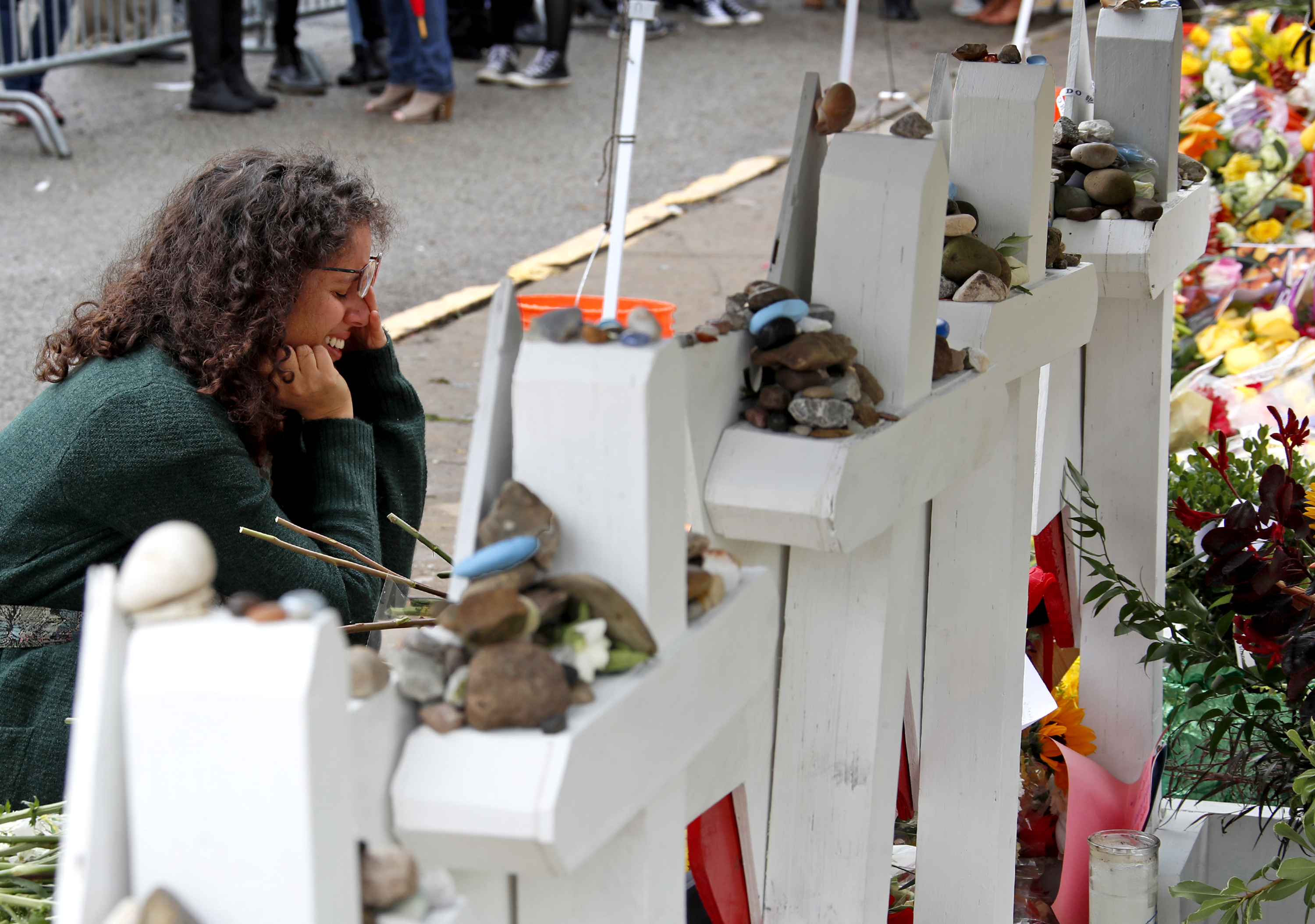 Anat Halevy Hochberg, of Brooklyn, NY., visits a makeshift memorial outside the Tree of Life synagogue where 11 people were killed on Oct. 27 while worshipping, in the Squirrel Hill neighborhood of Pittsburgh, Thursday, Nov. 1, 2018. (AP Photo/Gene J. Puskar)