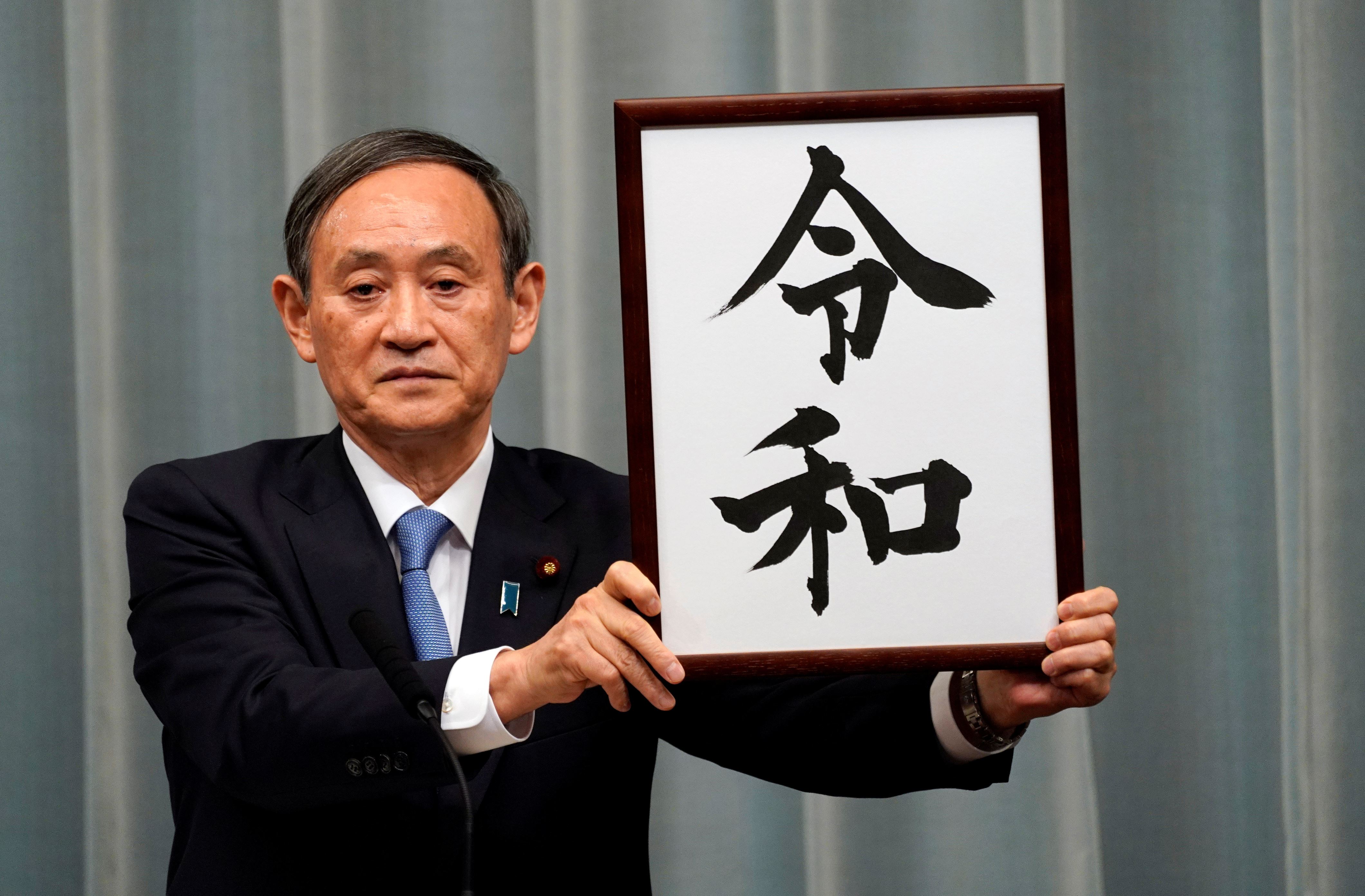 Japan's Chief Cabinet Secretary Yoshihide Suga unveils 'Reiwa' as the new era name at the prime minister's office in Tokyo, Japan, April 1, 2019.    Franck Robichon/Pool via Reuters