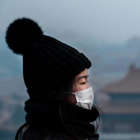 a person wearing a hat: BEIJING, CHINA - JANUARY 26: A Chinese girl wears a protective mask as she stands on an overlook towards the Forbidden City, which was closed by authorities, during the Chinese New Year holiday  on January 26, 2020 in Beijing, China. The number of cases of a deadly new coronavirus rose to over 2000 in mainland China Sunday as health officials locked down the city of Wuhan earlier in the week in an effort to contain the spread of the pneumonia-like disease. Medical experts have confirmed the virus can be passed from human to human. In an unprecedented move, Chinese authorities put travel restrictions on the city which is the epicenter of the virus, and neighboring municipalities affecting tens of millions of people. The number of those who have died from the virus in China climbed to at least 56 on Sunday, and cases have been reported in other countries including the United States, Canada, Australia, France, Thailand, Japan, Taiwan and South Korea. (Photo by Kevin Frayer/Getty Images)