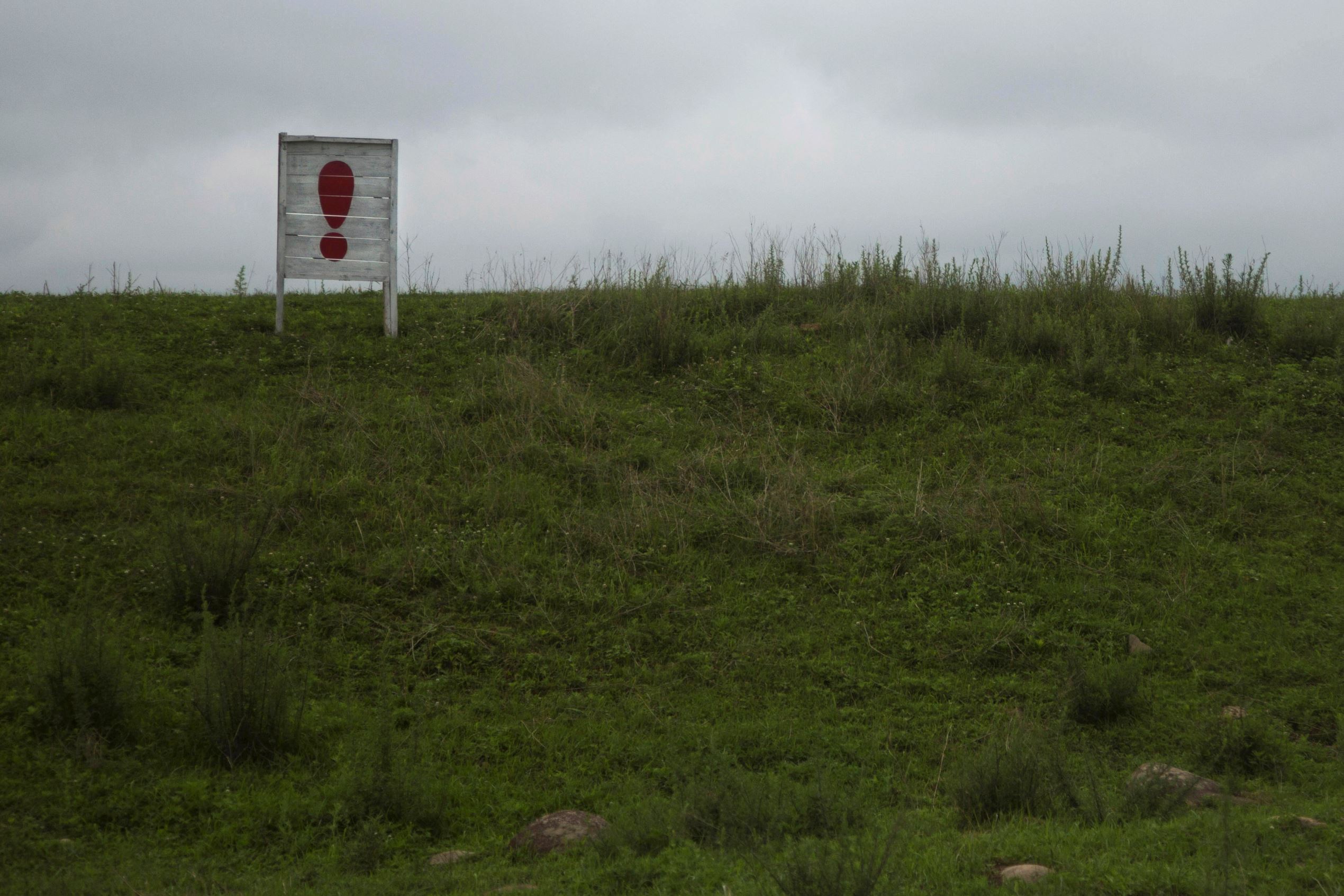 An exclamation point punctuates a long propaganda slogan in a field in North Korea's North Hamgyong province.
