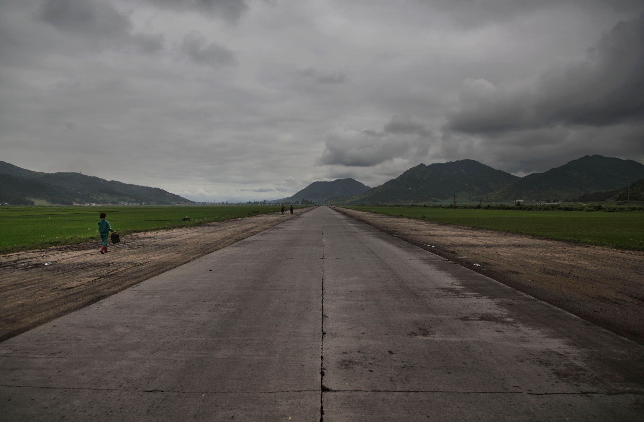A woman walks along an open road southeast of Pyongyang in North Korea's North Hwanghae province.