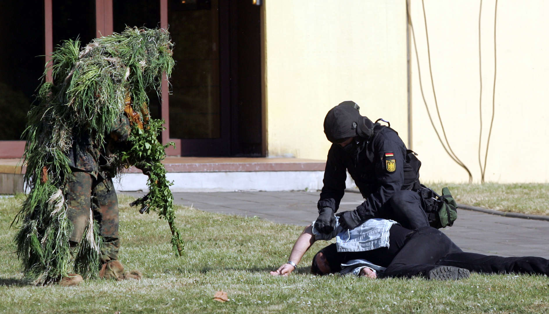 FILE - Special Police Forces Advance A mock target person during on exercise in Sankt Augustin, Germany western, on Friday, May 27, 2007. Special police forces from Germany, Austria , Denmark, Belgium and the Czech Republic joined the joint exercise to free hostages. Officer left wears a special camouflage suit for snipers. (