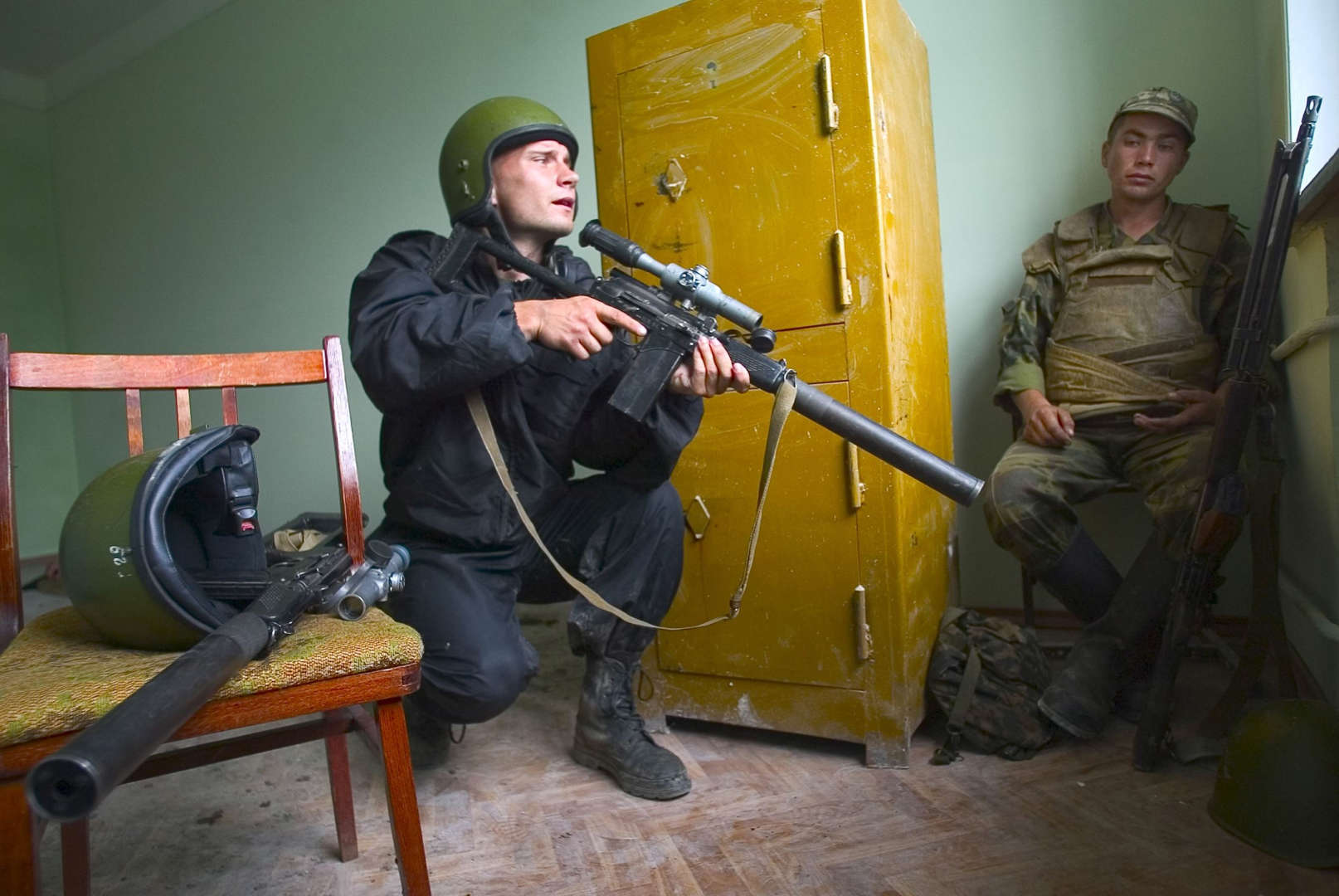 SHELL SHOCKED REGULAR ARMY SOLDIER HIDES BEHIND SAFE, AS SPETSNAZ SNIPER GETS READY FOR FIRE.