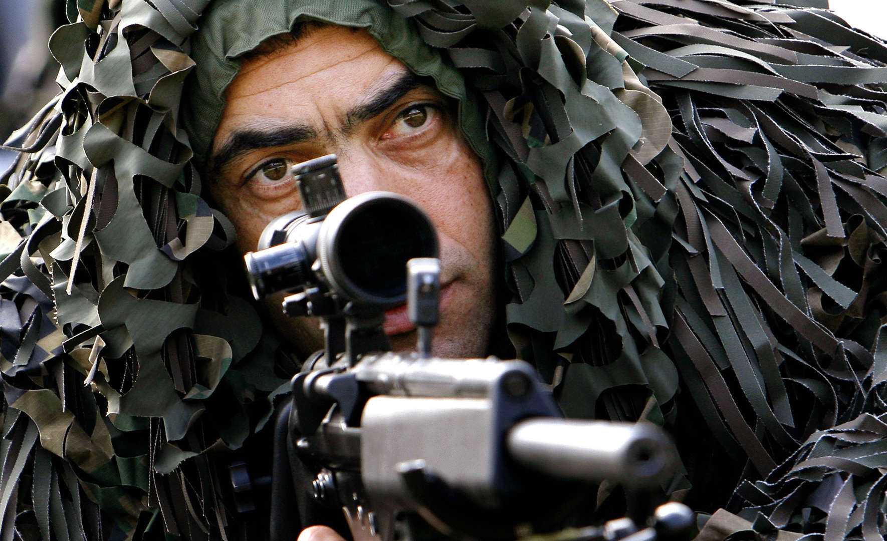 A Romanian special forces sniper looks on during a joint practice session involving Interior Ministry troops on the outskirts of Bucharest Romania Wednesday March 12 2008. The exercise is part of preparations by all branches of the Romanian security services for the upcoming NATO Summit that will take place in Bucharest between April 2-4 2008.(