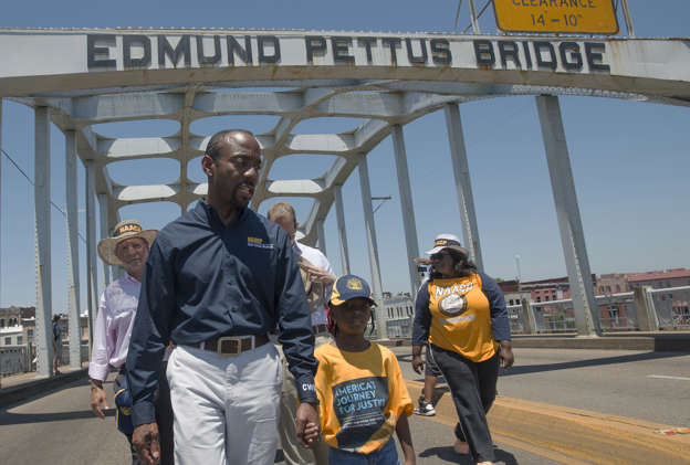 Cornell William Brooks, NAACP president, holds the hand of Rachel Quarterman, 7, while leading the "America&#39;s Journey for Justice March" organized by the NAACP on Saturday, Aug. 1, 2015, in Selma, Ala.